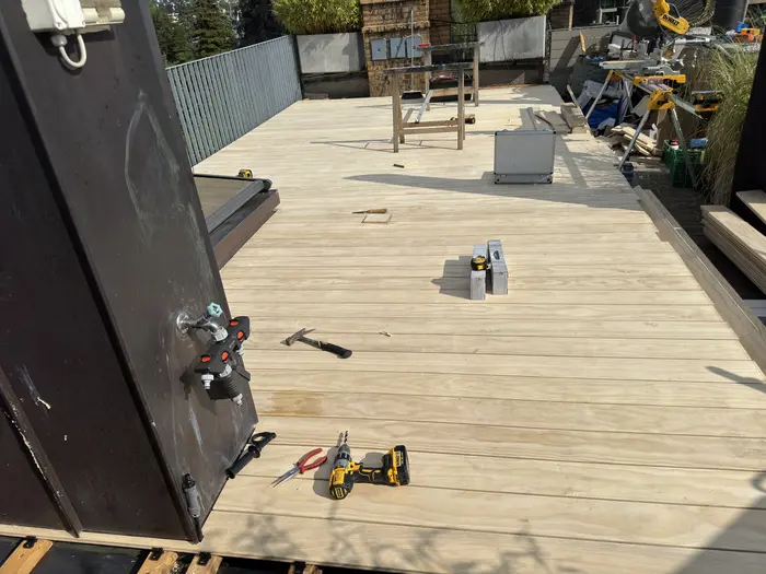 Fertig verlegtes Holzdeck rund um Dachfenster und Kamin