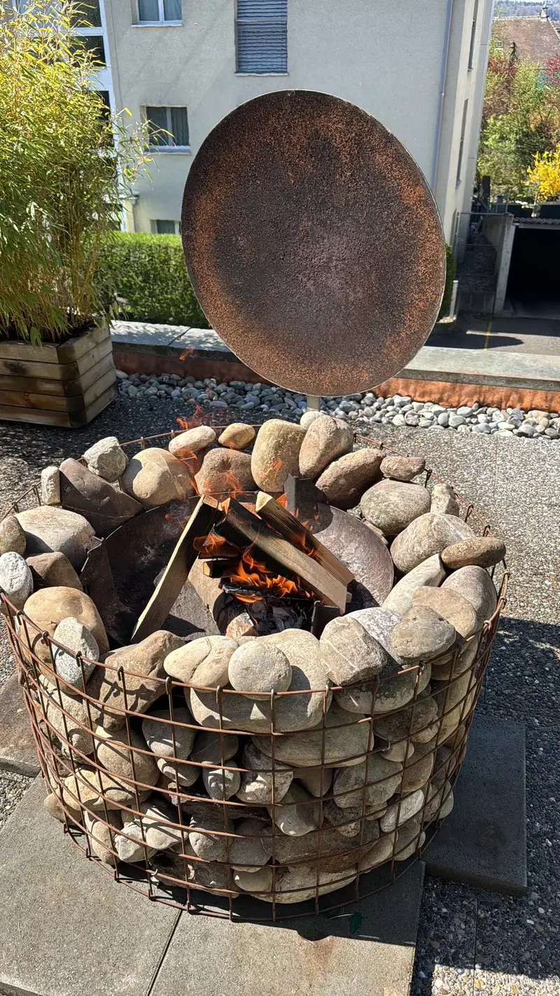 Feuerstelle aus Gabionen mit Feuerplatte im Garten