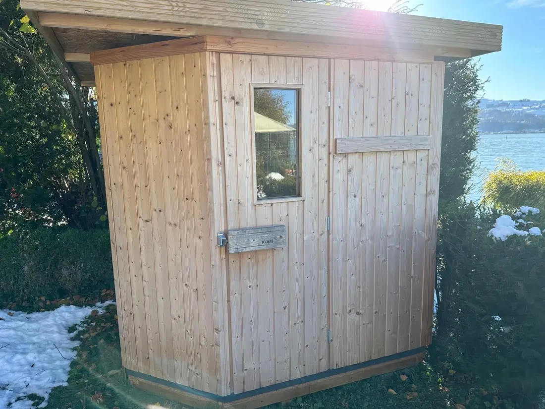 Gartensauna aus hellem Holz am Zürichsee