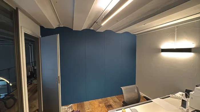 Blaue Schrankwand, die der Deckenkontur eines Büros folgt