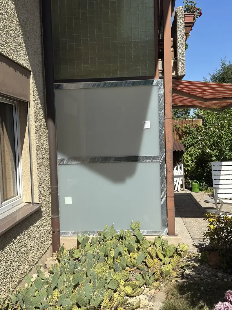 Sichtschutz aus Milchglas im verzinkten Rahmen an einer Fassade